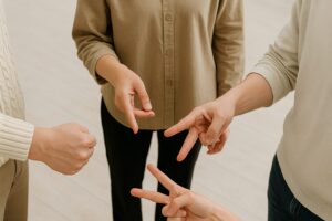 4人がそれぞれグー・チョキ・パーを出してじゃんけんをしている手元の様子。