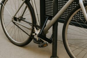 街中の黒いフェンスにロックされた自転車。鍵がリングロックに取り付けられたままになっている様子が確認できる。