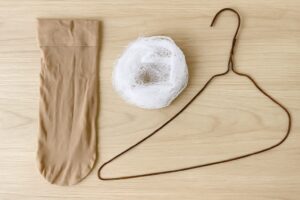 ストッキング、ハンガー、100均の洗濯ネットが並べられた様子。即席のゴミ取りネット代用品として紹介されるアイテム。