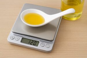 キッチンカウンターに置かれたデジタルスケールに、小皿とスプーンが乗っている様子。