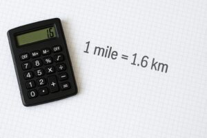 電卓と「1 mile = 1.6 km」と書かれたグラフ用紙の上からの写真