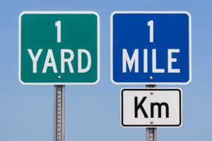 「1 YARD」「1 MILE」「Km」と表示された道路標識の並び