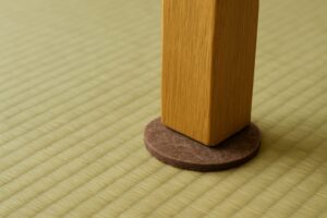 畳の上に敷かれたフェルトパッドと木製家具の脚の接地面