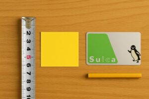 テーブルの上に置かれたメジャー、黄色い折り紙、Suicaカードで5センチを比較できるように並べられている様子。