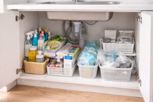 整理前で物が雑多に置かれているシンク下収納の様子