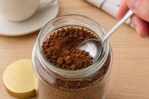 スプーンを使って固まったインスタントコーヒーをほぐしている様子